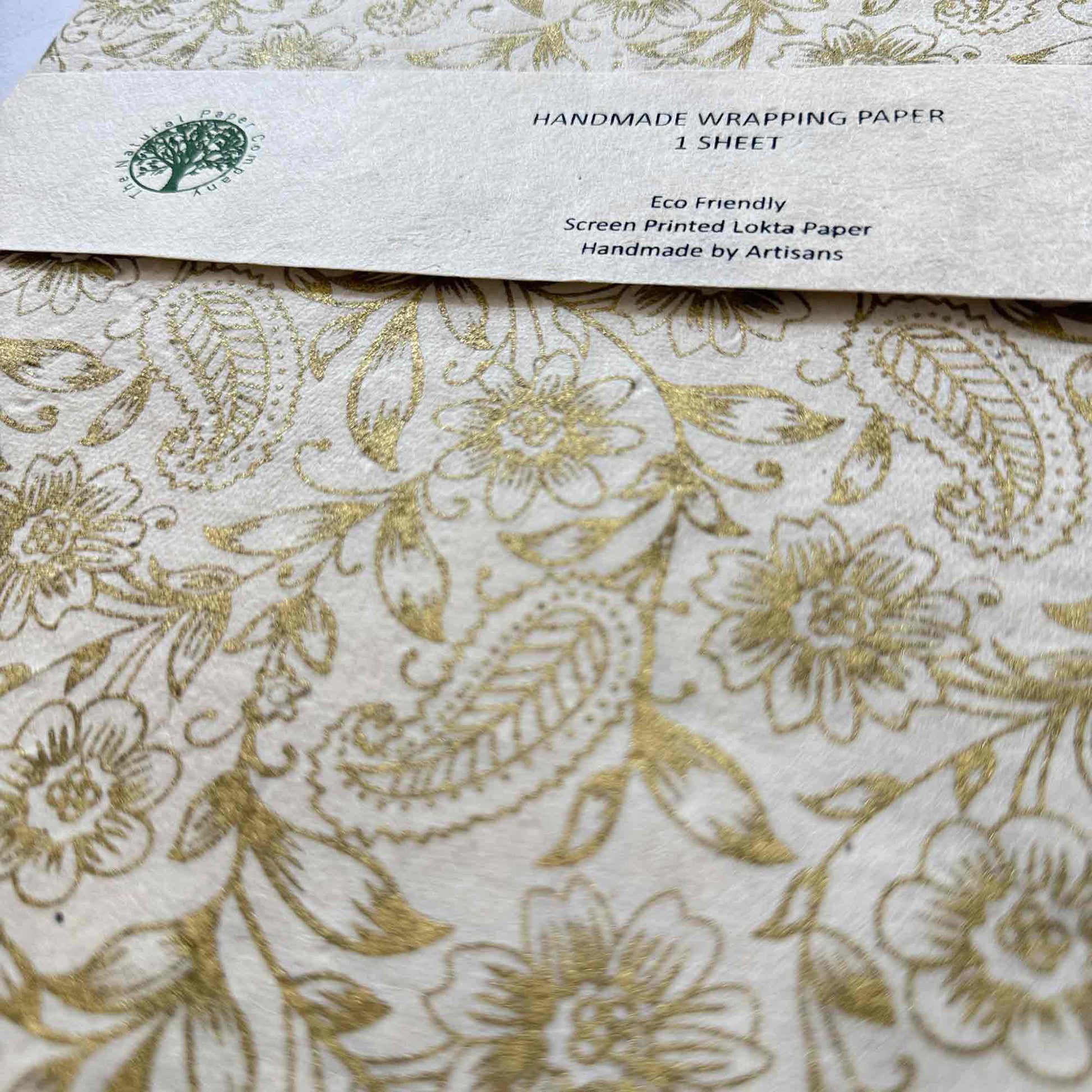 Close-up of hand screen printed gold floral and paisley design on natural textured Lokta paper
