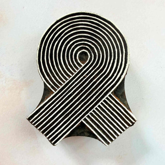 Swirl Indian wood block stamp — elegant spiral ribbon face-on view, hand-carved traditional printing block on neutral background