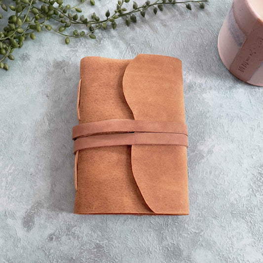 Small tan leather notebook in A6.  Made by hand with recycled cotton rag paper pages