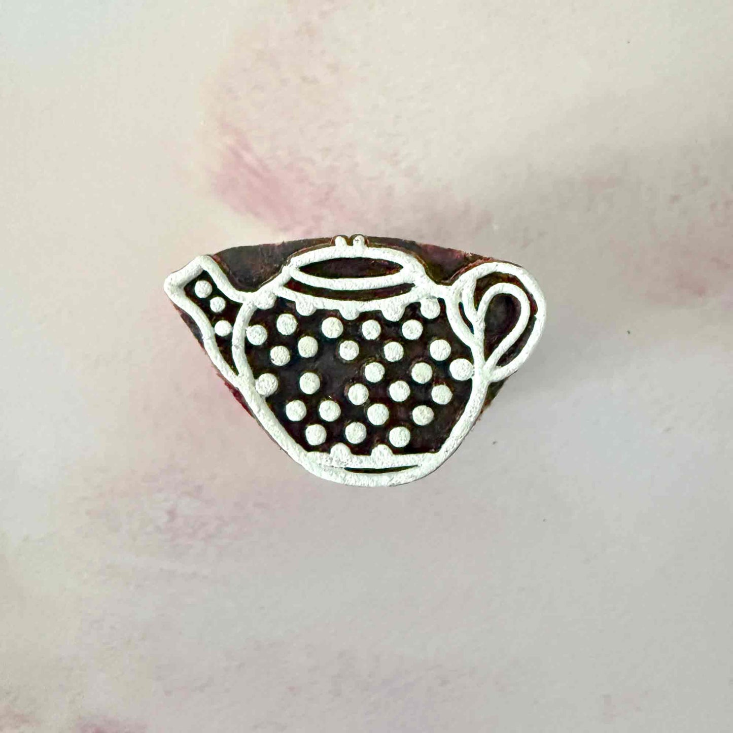 wooden stamp with small spotty teapot design. 
