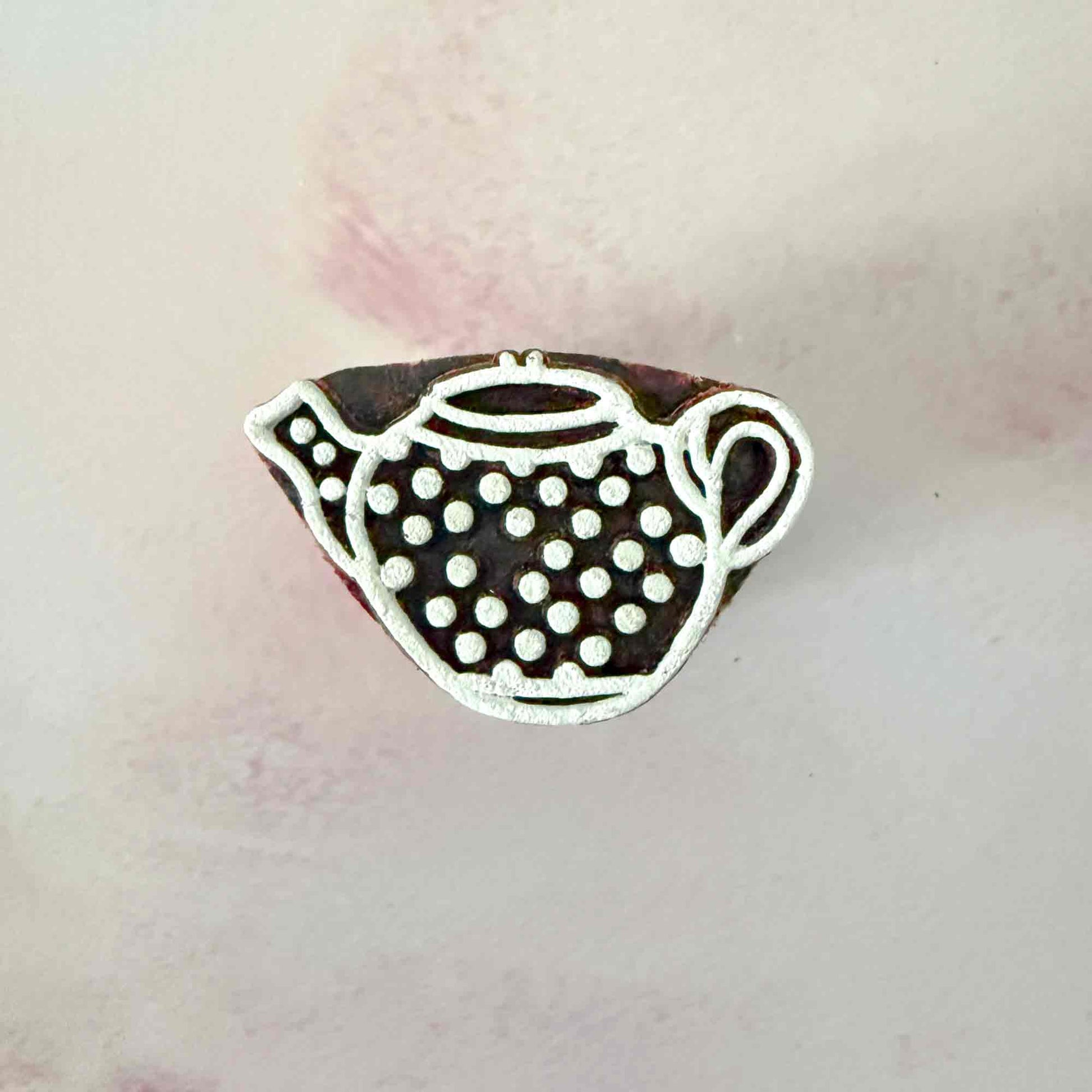 wooden stamp with small spotty teapot design. 
