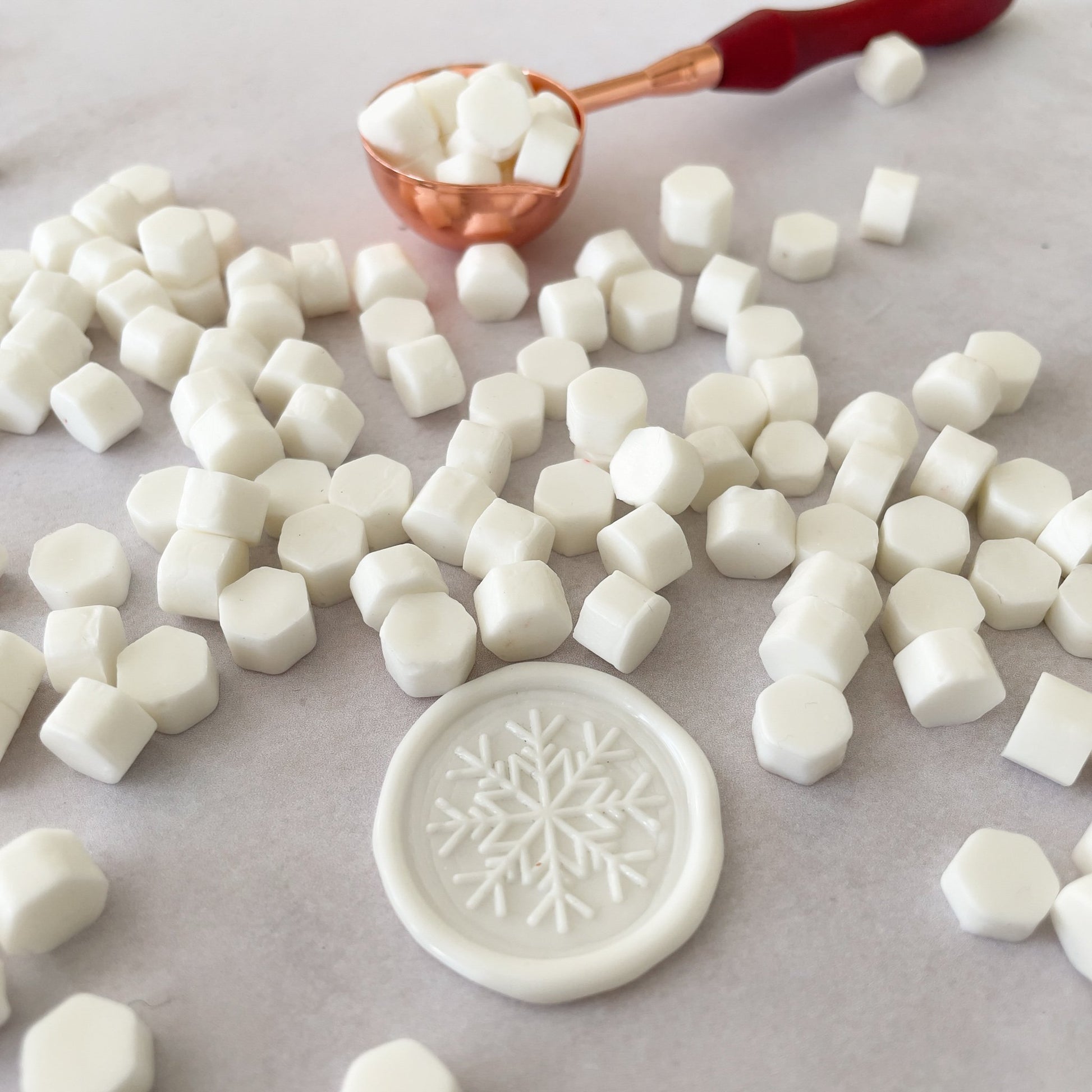 White wax seals made with  eco friendly sealing wax beads.  Easily make wax seals with a sealing wax beads and a melting spoon by The Natural Paper Company