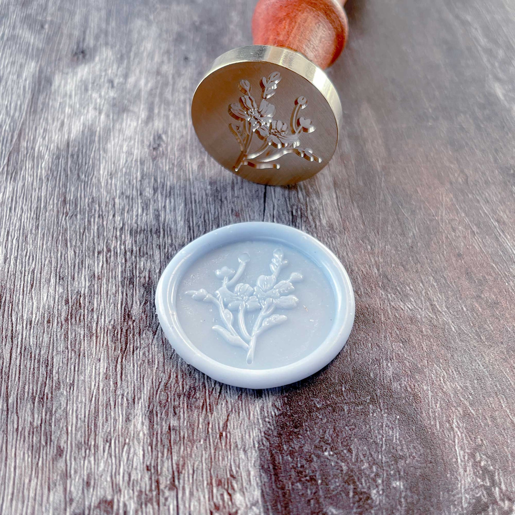 Light blue wax seals with a pretty flower design.  Make floral wax seals with a sealing wax stamp by The Natural Paper Company