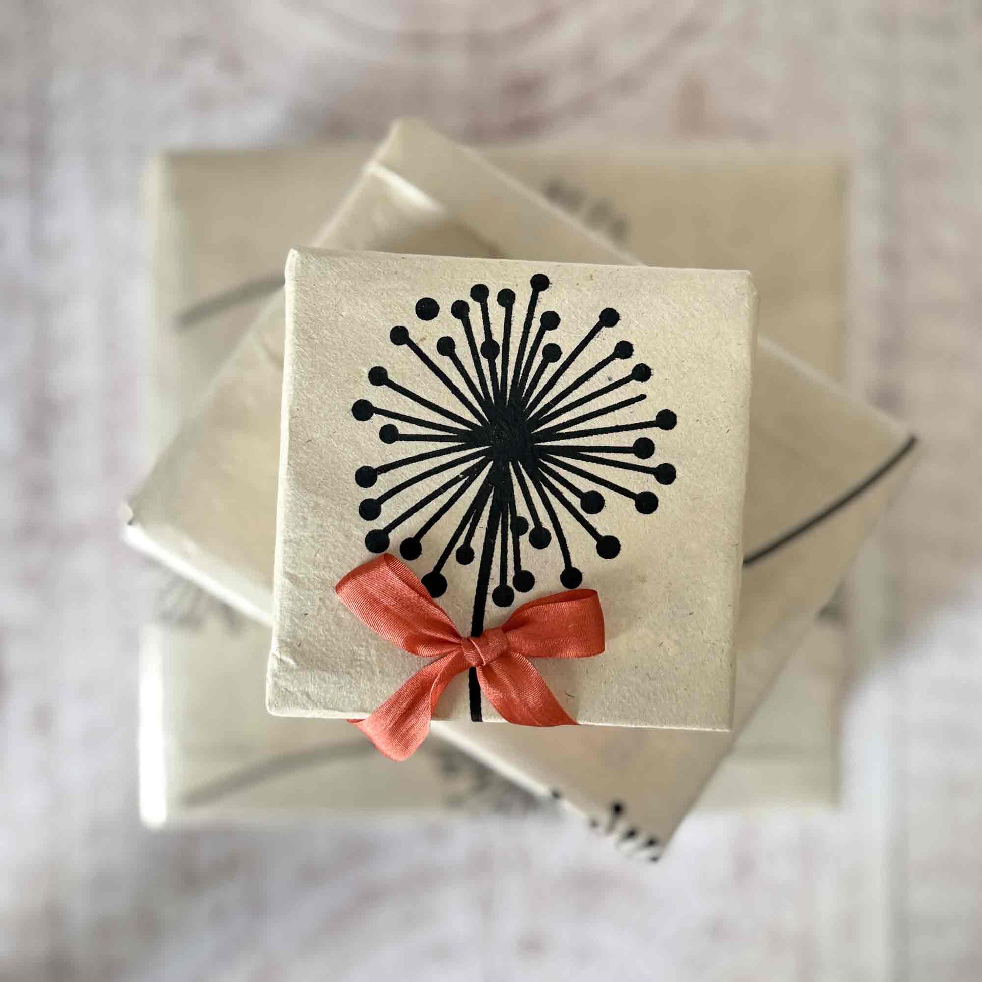Small gift box wrapped in natural Lokta paper, dandelion print, finished with rust silk ribbon