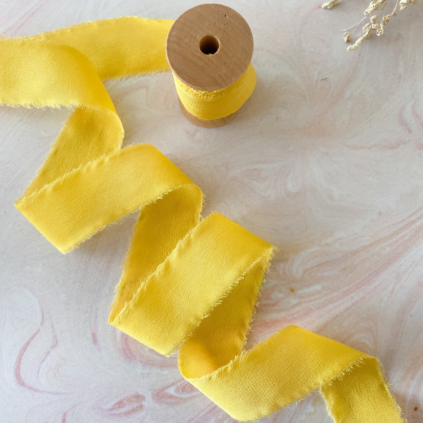 Yellow silk ribbon for crafts.  Luxury silk ribbon with a frayed edge.  Sold on a wooden reel.  By The Natural Paper Company.