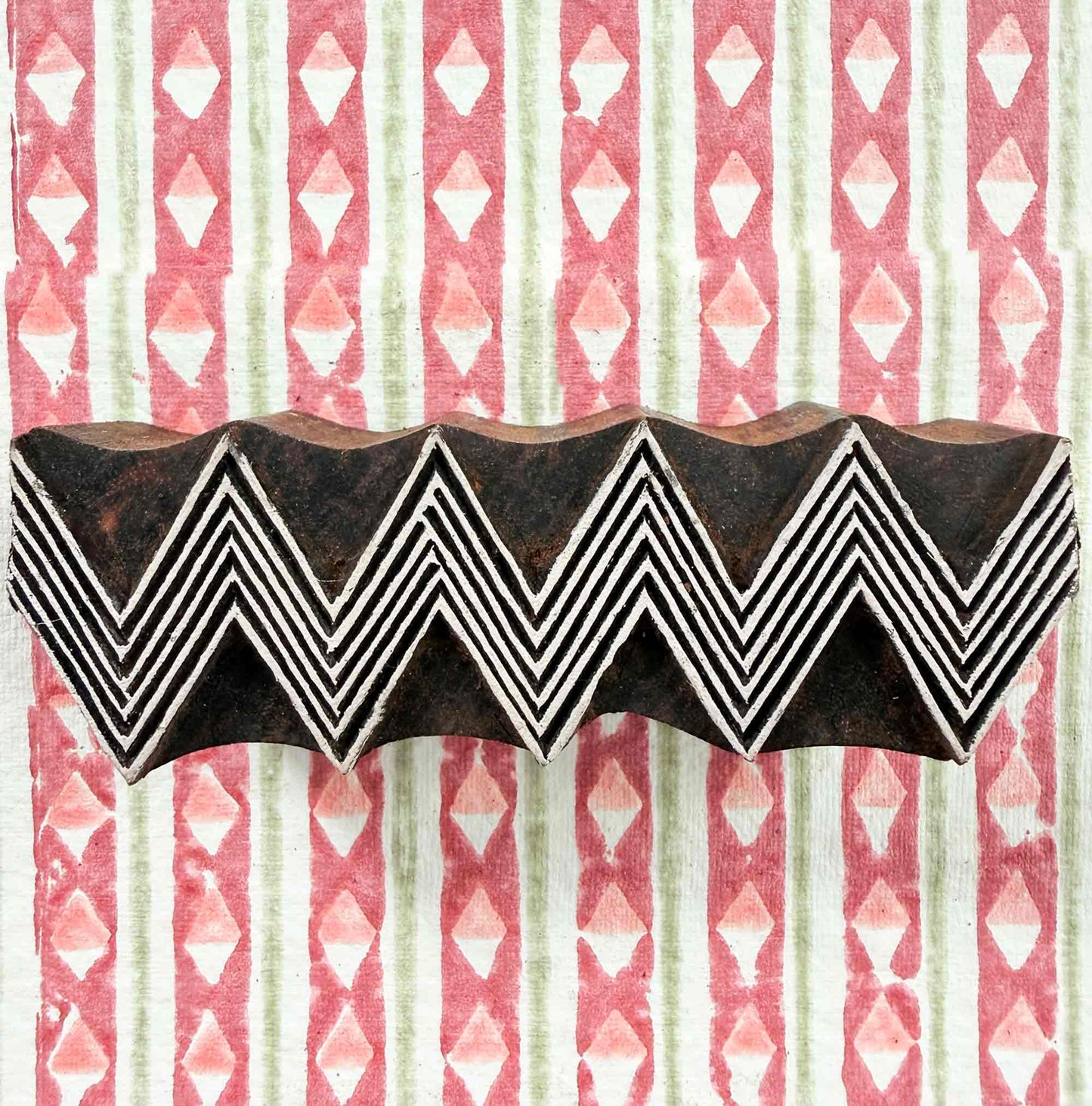 ZigZag wooden stamp — four lined chevrons face-on resting on block printed fabric, bold geometric border design, handcrafted Indian printing block