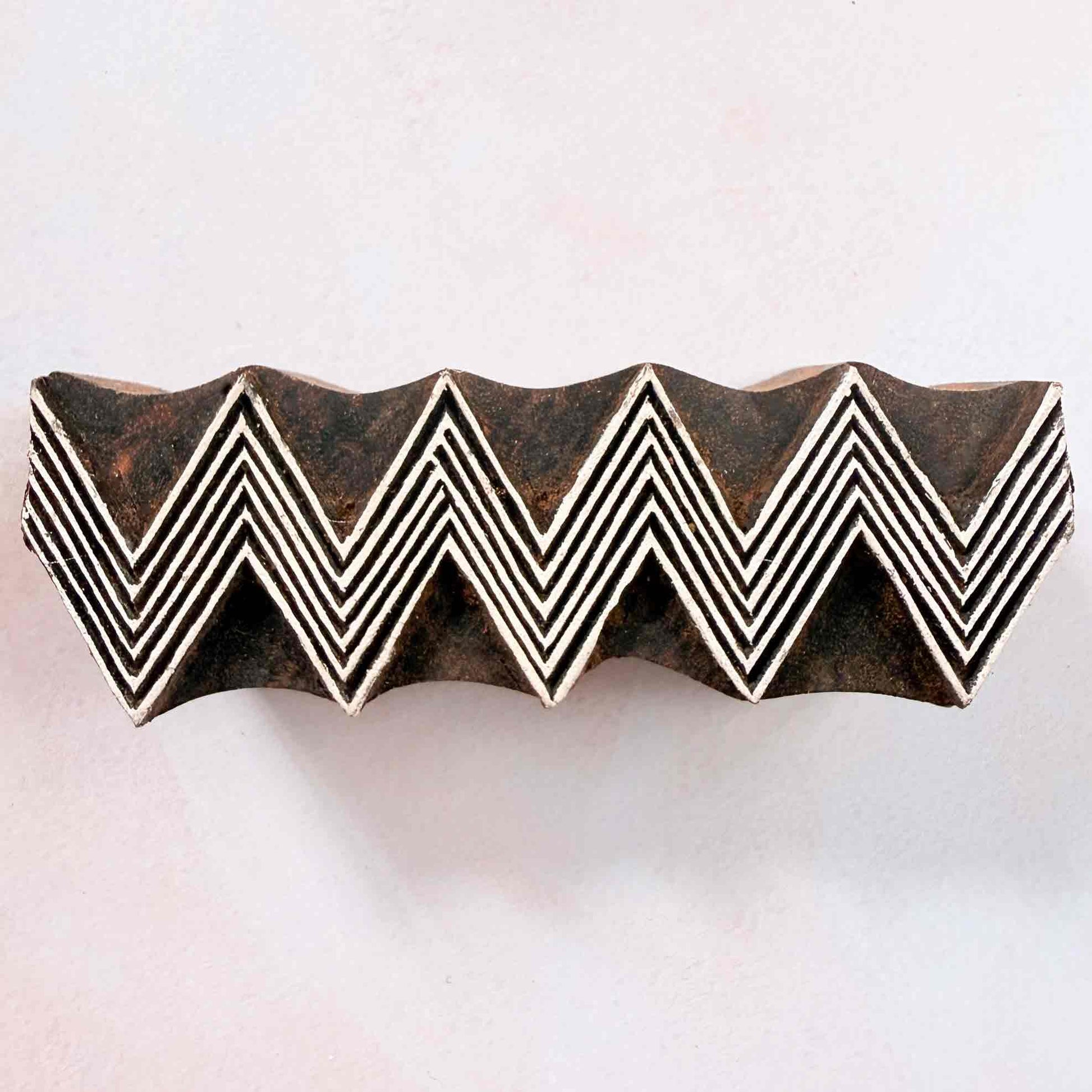 ZigZag Indian wood block stamp — lined chevron border face-on view on soft pale background, repeating V-shape pattern, authentic hand-carved traditional printing block