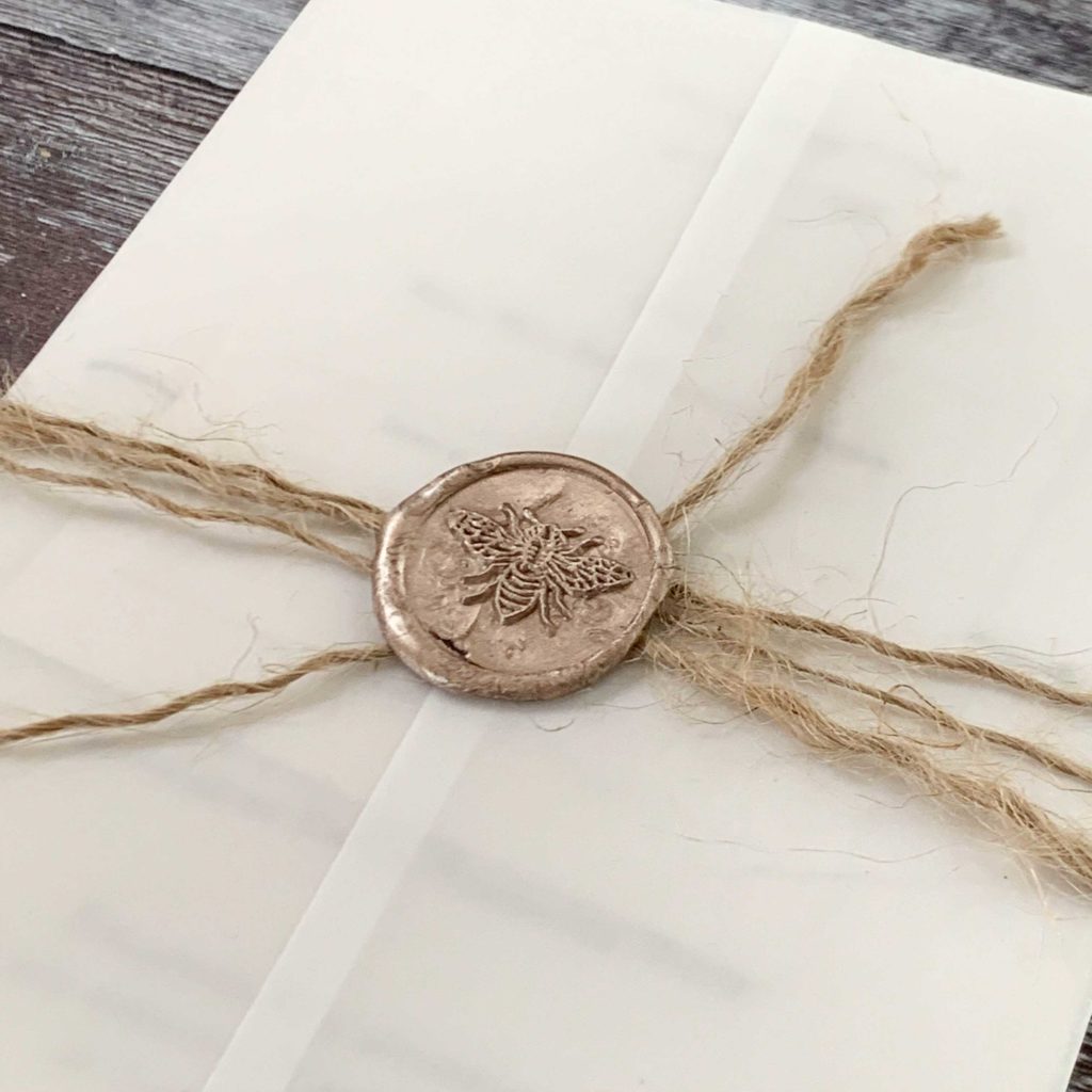 Eco friendly wedding invitation with champagne gold wax seal.  Bee design wax seal.  Vellum invitation with gold wax seal and hemp string