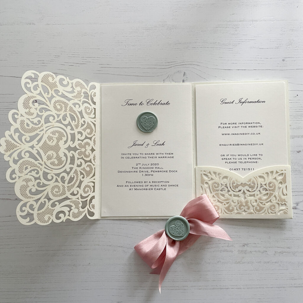 Wedding invitaiton made with wax seal and silk ribbon.  Save green, blush pink and ivory invitation.  Sage green wax seal with heart pattern.  Blush pink silk ribbon.  Ivory pocket invitation