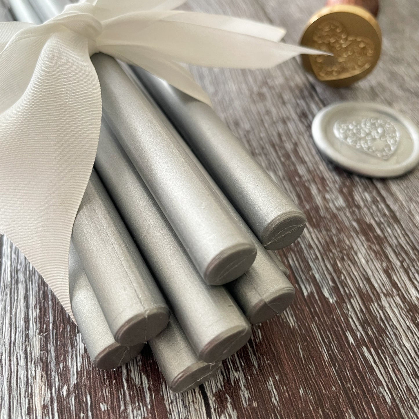 Eco friendly sealing wax sticks in metallic silver.  11mm glue gun sealing wax that can also be used with a melting spoon. Plastic free, Paraffin free and Biodegradable.  Make silver wax seals for decorating invitations, stationery, envelopes, packaging and more.  By The Natural Paper Company