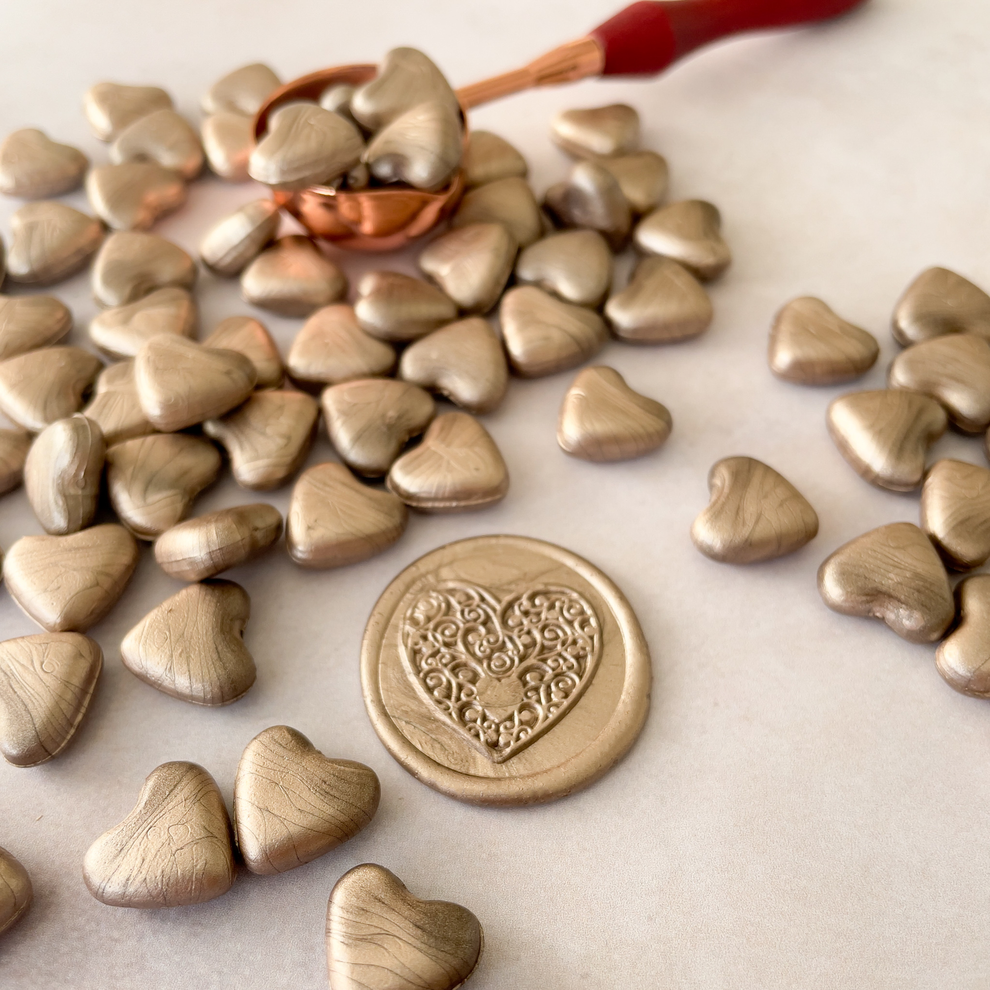 sealing wax beads in champagne gold.  Heart shaped beads of wax to melt in a melting spoon.  Make envelope seals, wax seals and wax stamps in champagne gold