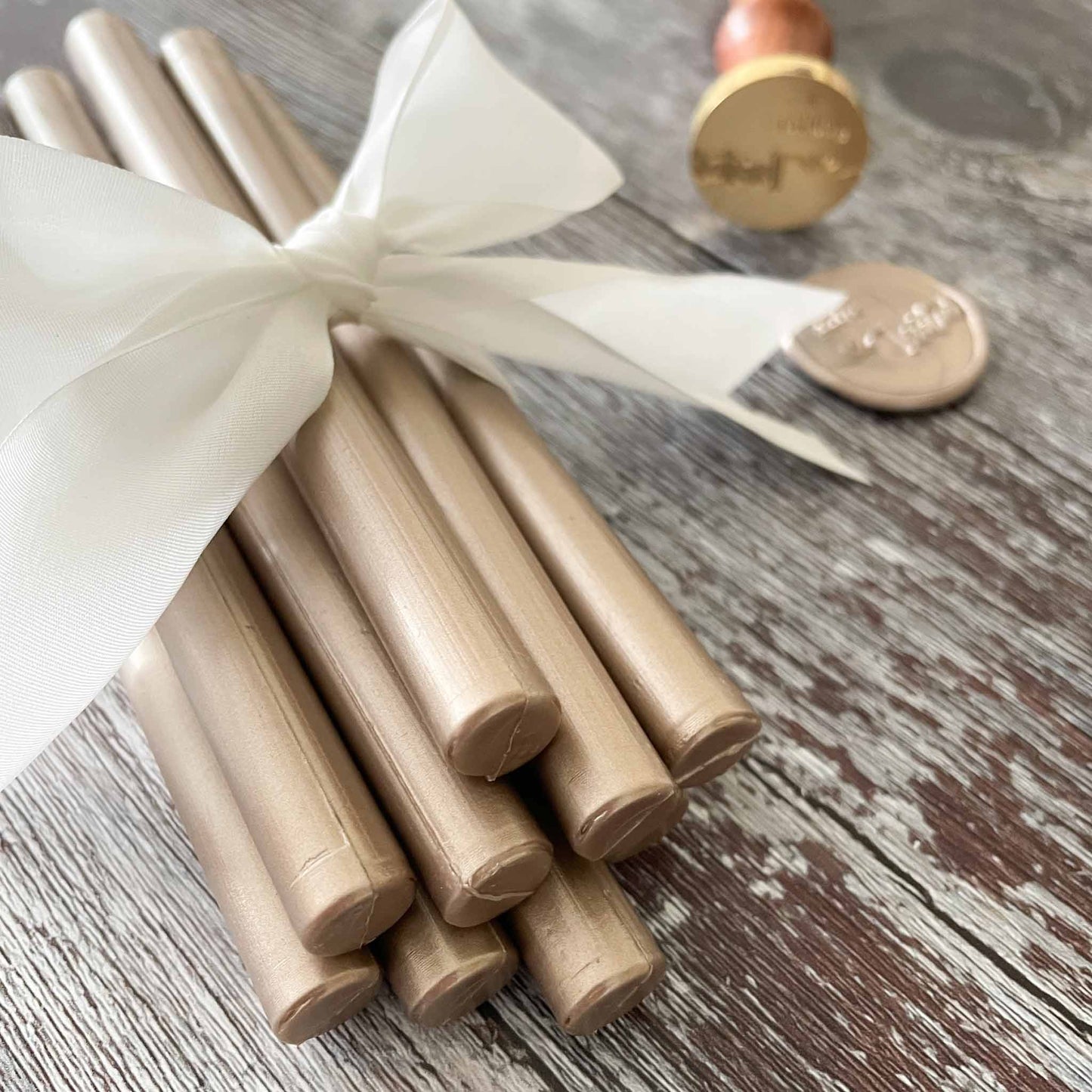 Champagne gold sealing wax sticks By The Natural Paper Company.  Make eco friendly wax seals using plastic free, paraffin free and biodegradable wax.  Suitable for adding wax seals to invitations, stationery, envelopes and packing.  Use with your choice of wax seal stamps.  By The Natural Paper Company