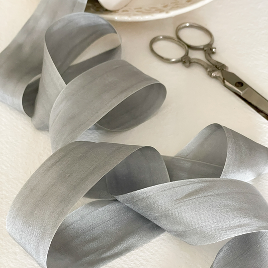 silver grey silk ribbon sold by the meter.  Luxury habotai silk ribbon with a closed edge finish