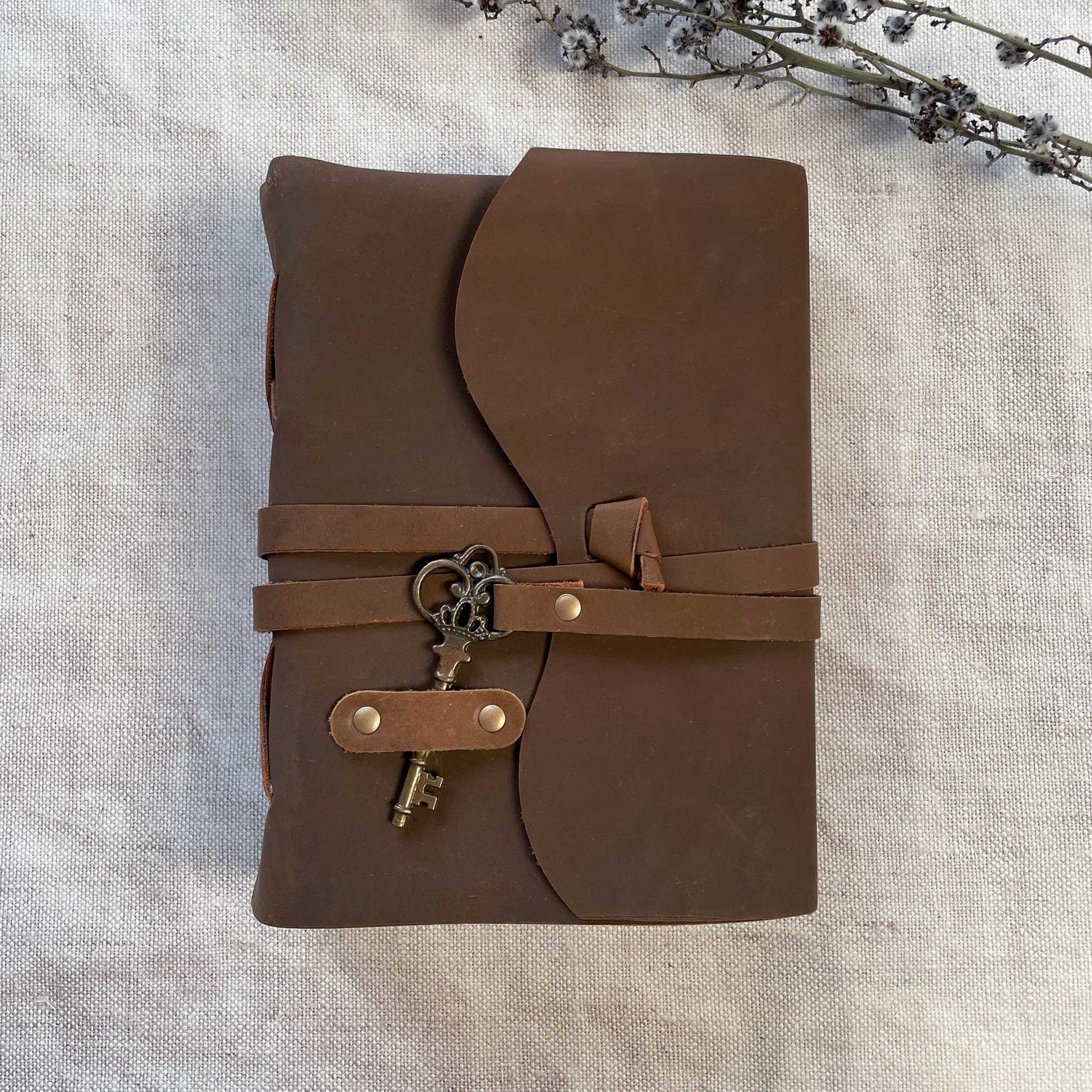 Leather cover notebook with key and loop fastening.  Handmade cotton rag paper journal with brown leather cover.