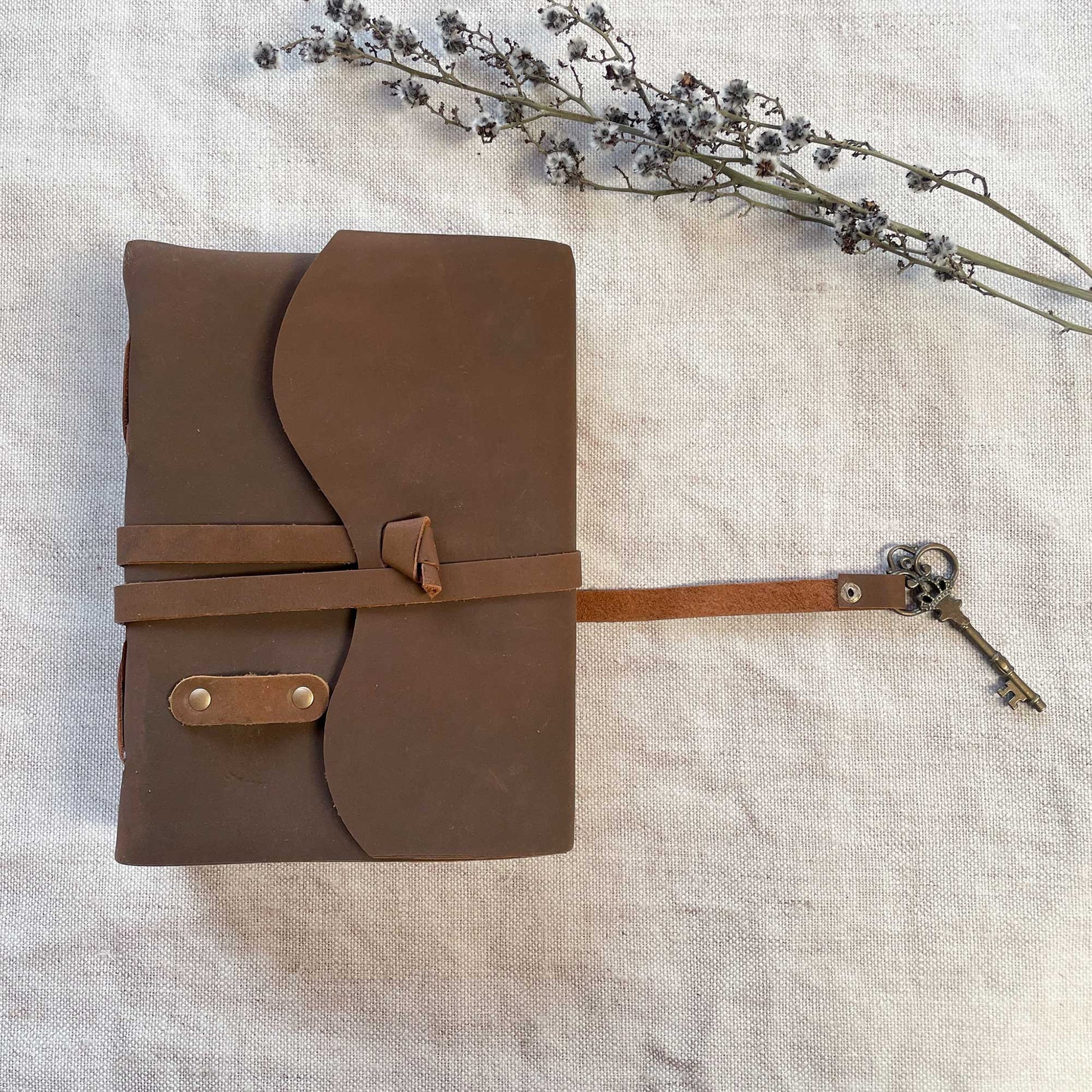 leather journal with handmade paper pages.  Brown leather cover with recycled paper pages and key fastening