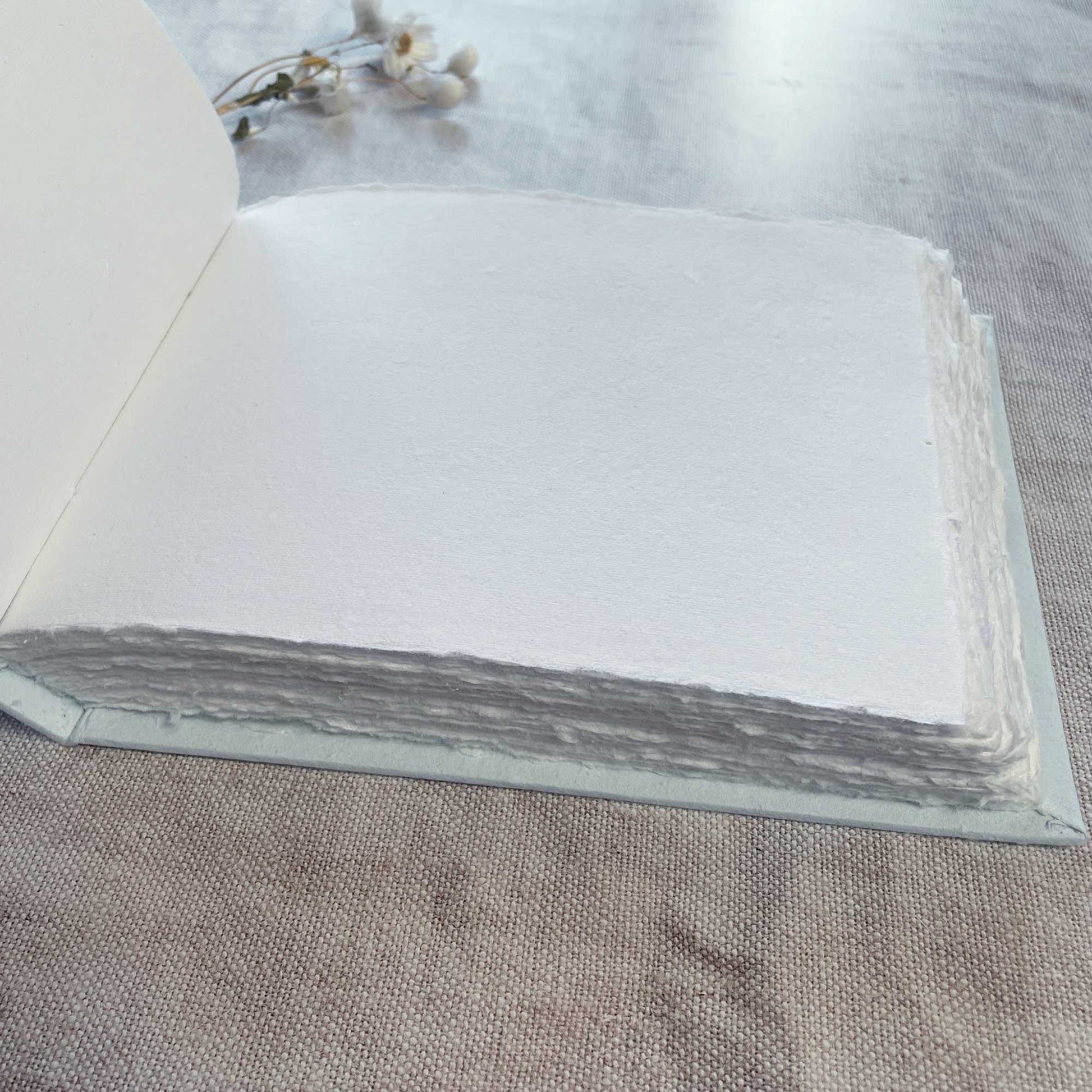 Blank journal made from recycled cotton rag paper with light blue hard cover.  Perfect to use as a guest book or artist sketch pad.  100 deckle edge pages.  Hand bound