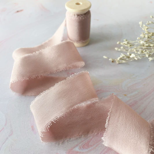 nude blush habotai silk ribbon with frayed edge.  Natural silk ribbon in pale blush pink.  Sold on a wooden spool