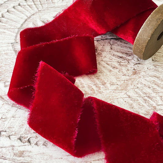 red velvet ribbon made from silk.  Luxury velvet ribbon with frayed edge.  Silk velvet in bright red