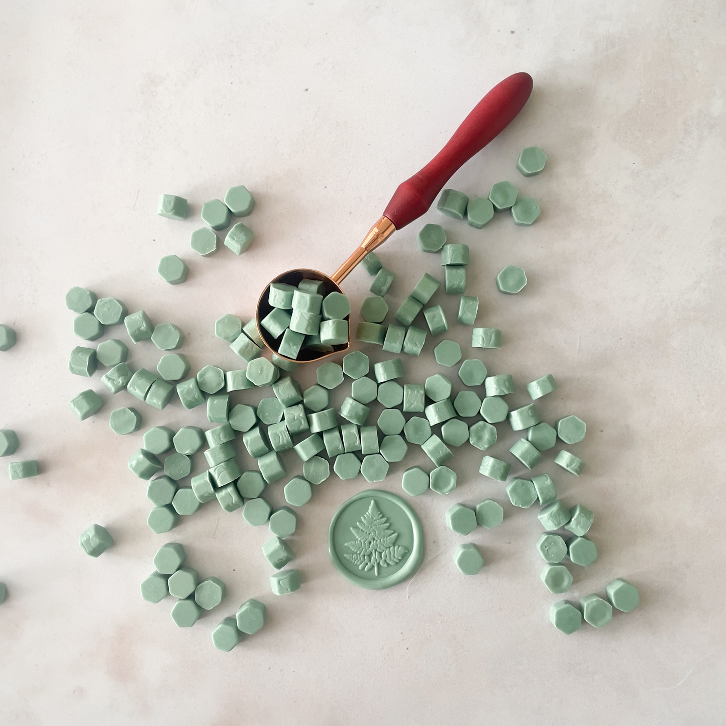 sage green colour wax beads to melt with a melting spoon.  Sealing wax beads in a dusky green colour.
