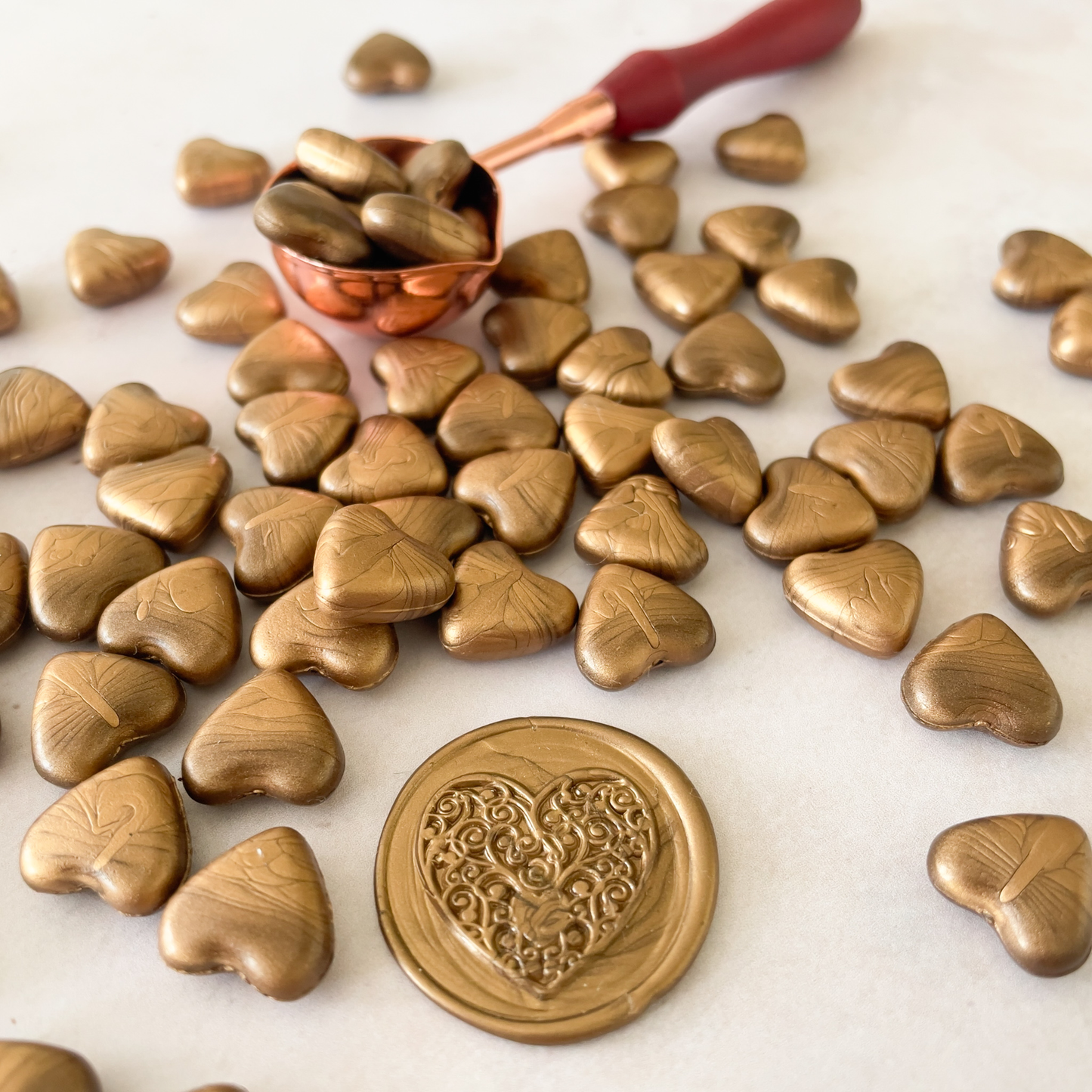 sealing wax beads in metallic gold colour.  Heart shaped wax beads for making wax seals and stamps.  